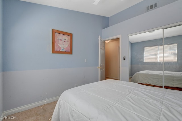 bedroom with ceiling fan, a closet, and light carpet