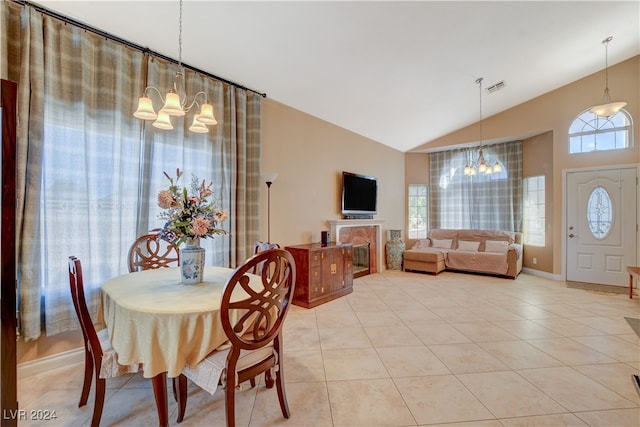 dining area with lofted ceiling, a chandelier, a fireplace, and a healthy amount of sunlight