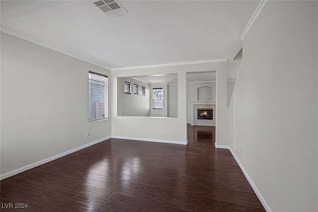 unfurnished living room with crown molding and dark hardwood / wood-style floors