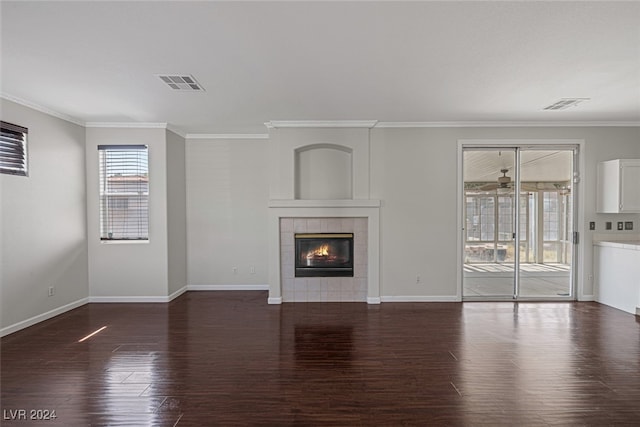 unfurnished living room with dark wood-type flooring, crown molding, and a fireplace