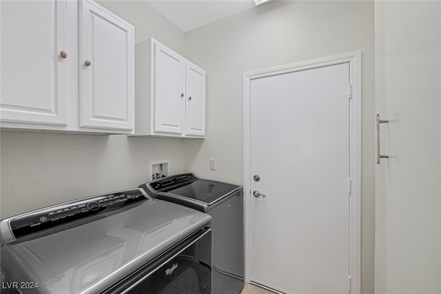 washroom with cabinets and washing machine and clothes dryer