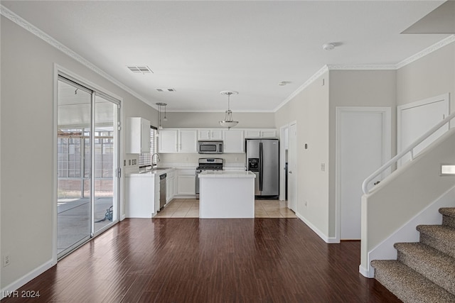 kitchen featuring stainless steel appliances, sink, pendant lighting, light wood-type flooring, and white cabinetry