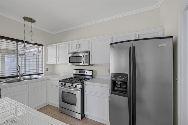 kitchen featuring appliances with stainless steel finishes, sink, tile countertops, white cabinets, and light tile patterned floors