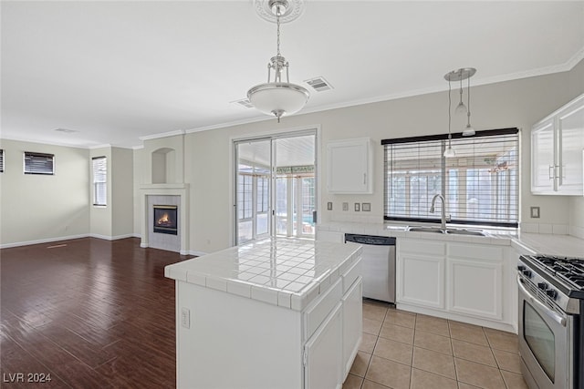 kitchen with sink, white cabinetry, stainless steel appliances, and light wood-type flooring