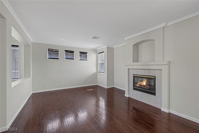 unfurnished living room featuring wood-type flooring, ornamental molding, and a fireplace