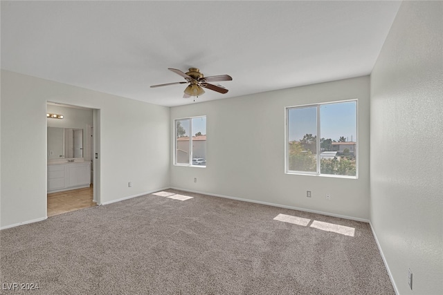 carpeted spare room featuring ceiling fan