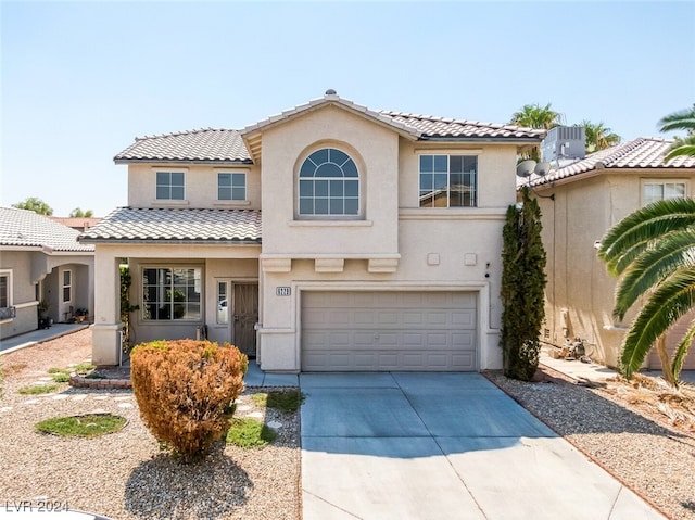 mediterranean / spanish home with a garage