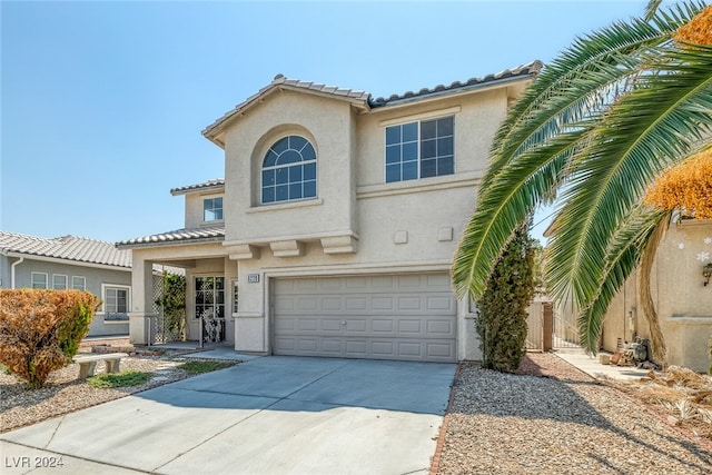 mediterranean / spanish-style home with a garage