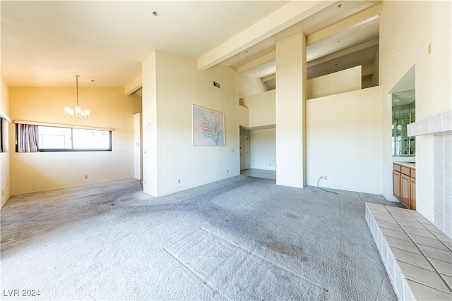 unfurnished living room featuring a notable chandelier, light carpet, and lofted ceiling with beams