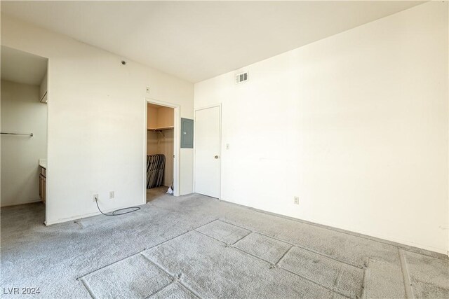 unfurnished bedroom featuring electric panel, a closet, and a spacious closet