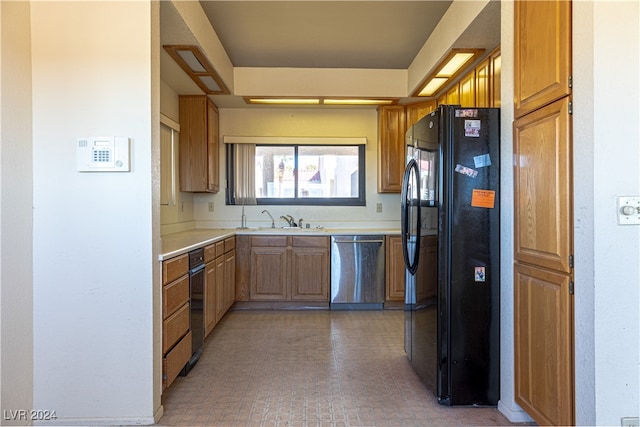 kitchen featuring dishwasher, sink, and black fridge