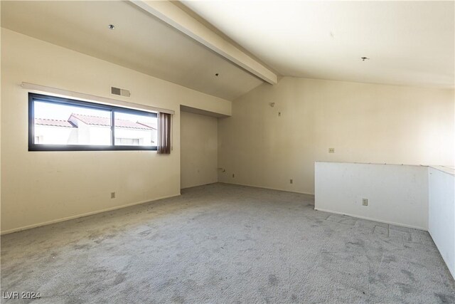 spare room with lofted ceiling with beams and light colored carpet