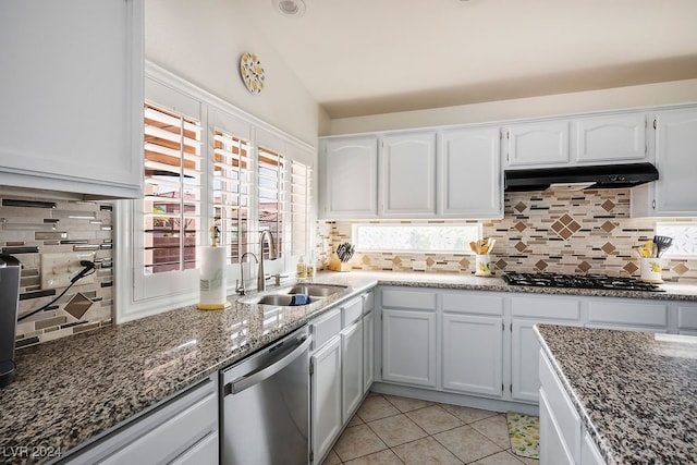 kitchen with backsplash, light tile patterned floors, dishwasher, white cabinetry, and lofted ceiling