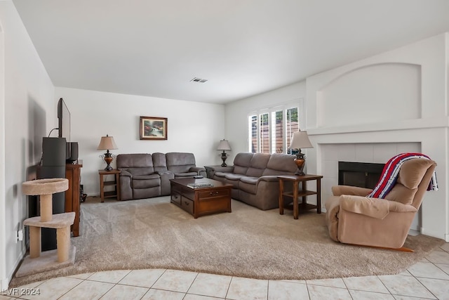 living room with light carpet and a tile fireplace