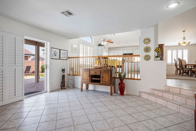 interior space with ceiling fan with notable chandelier