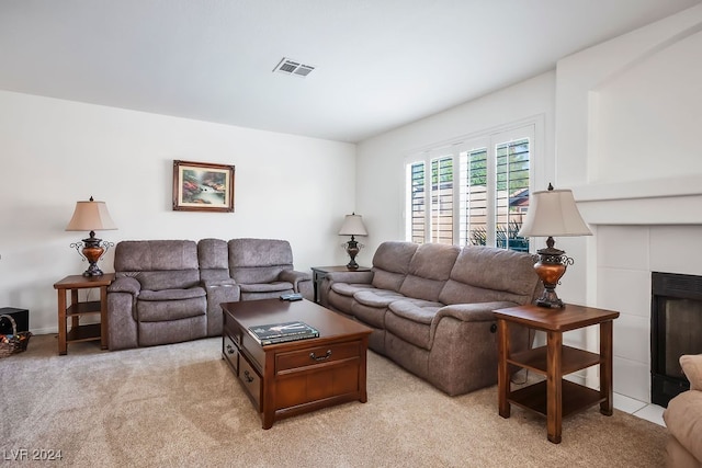 carpeted living room with a tile fireplace