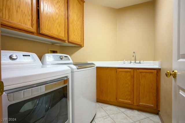 laundry area with washer and dryer, cabinets, sink, and light tile patterned floors