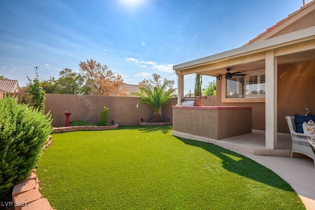 view of yard with ceiling fan and a patio area