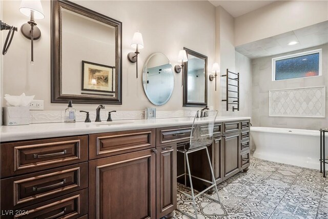 bathroom with a tub to relax in, tile patterned flooring, and vanity