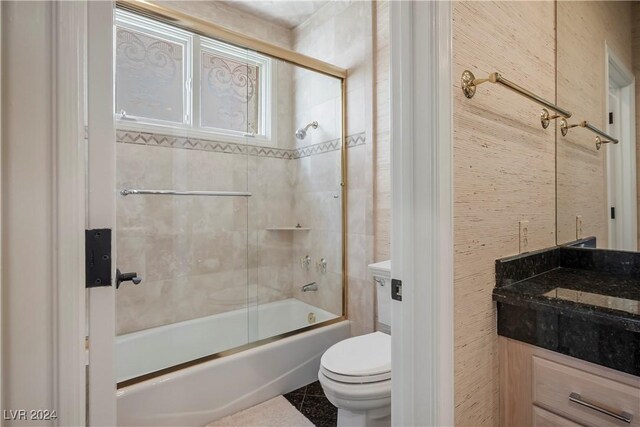 full bathroom featuring vanity, toilet, and bath / shower combo with glass door