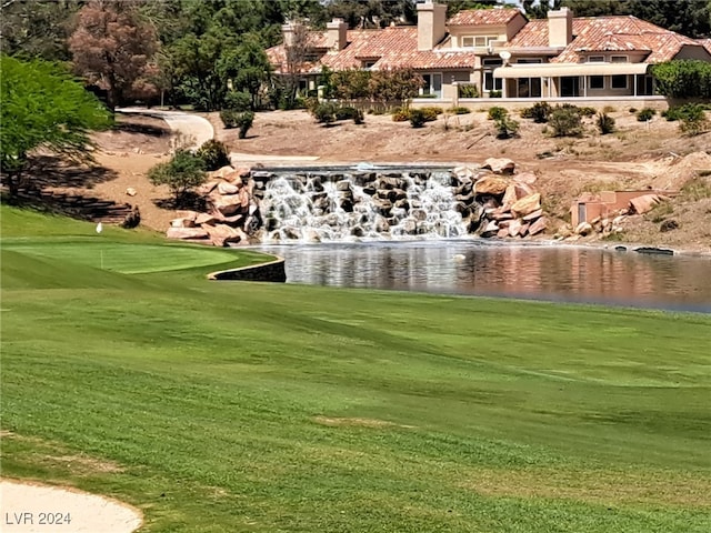 view of home's community with a yard and a water view