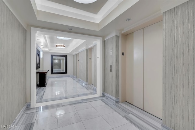 hall featuring elevator and a raised ceiling