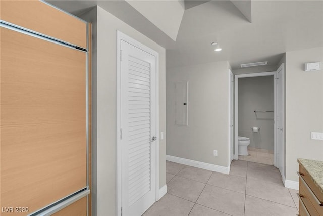 bathroom with toilet, vanity, electric panel, and tile patterned floors