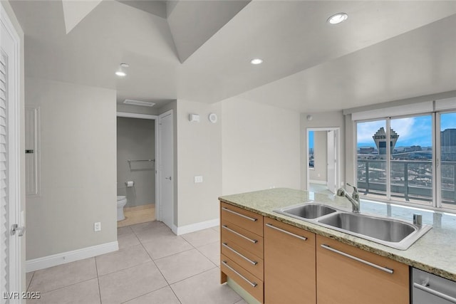 kitchen with dishwasher, light stone countertops, sink, and light tile patterned floors