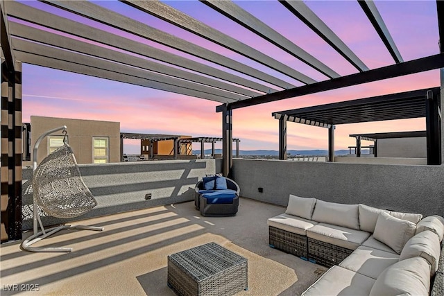 patio terrace at dusk featuring a pergola and outdoor lounge area