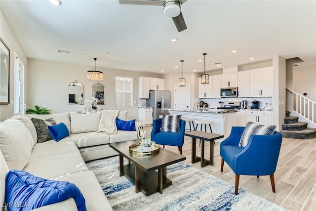 living room with a wealth of natural light, light hardwood / wood-style flooring, and ceiling fan