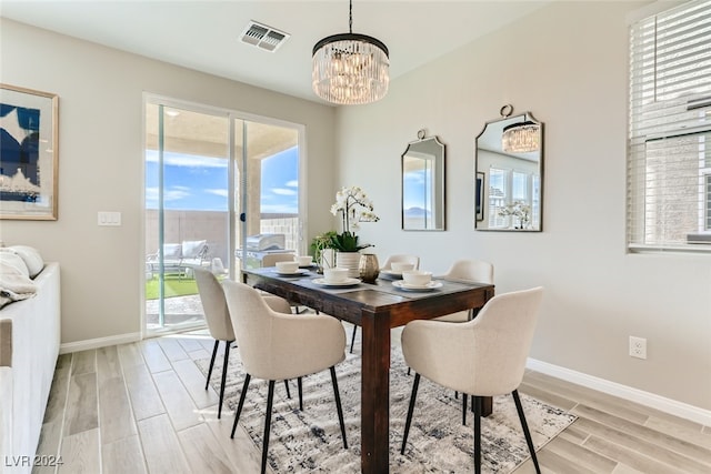 dining area featuring light wood-type flooring and a chandelier