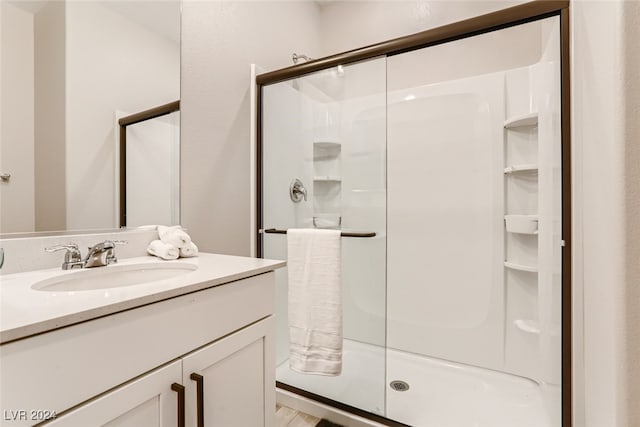 bathroom with hardwood / wood-style floors, an enclosed shower, and vanity