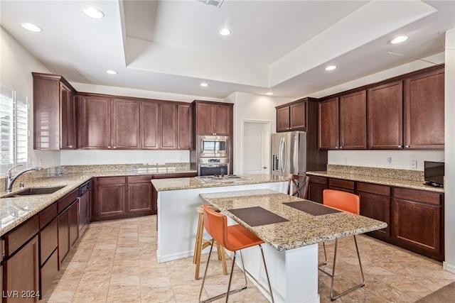 kitchen featuring a breakfast bar area, sink, appliances with stainless steel finishes, and a kitchen island