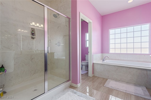 bathroom featuring separate shower and tub and toilet