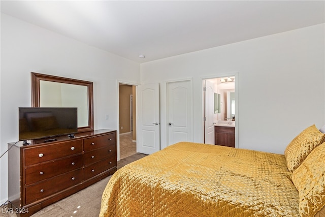 bedroom featuring ensuite bathroom and carpet flooring