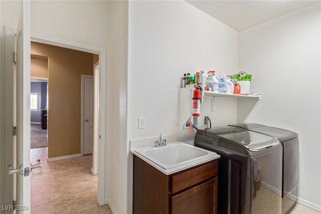 clothes washing area featuring sink and washer and clothes dryer