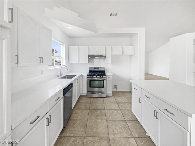 kitchen featuring backsplash, light tile patterned floors, stainless steel appliances, white cabinetry, and sink