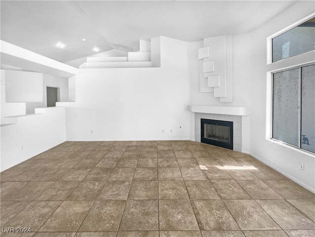 unfurnished living room featuring lofted ceiling and a fireplace