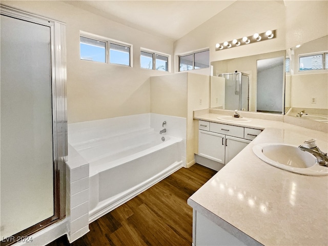 bathroom with lofted ceiling, separate shower and tub, hardwood / wood-style flooring, and vanity