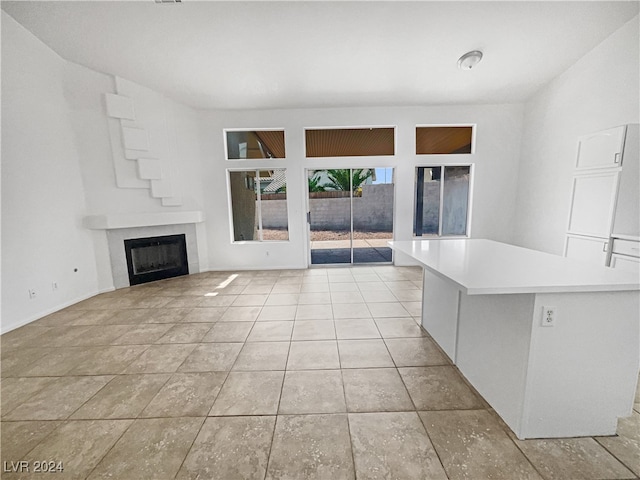 unfurnished living room featuring a tile fireplace