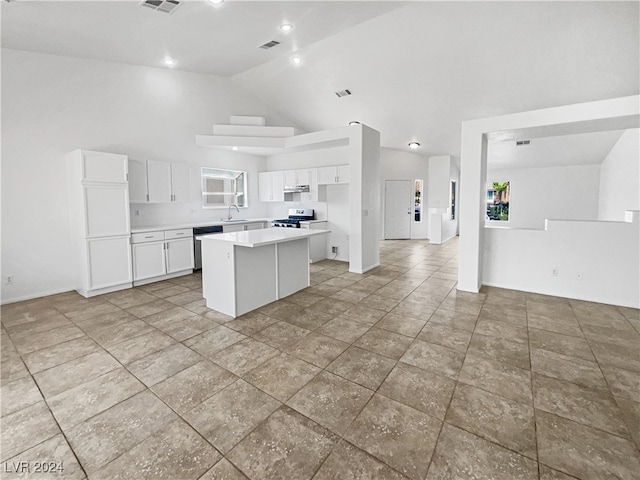 kitchen featuring white cabinets, a center island, stainless steel appliances, sink, and lofted ceiling