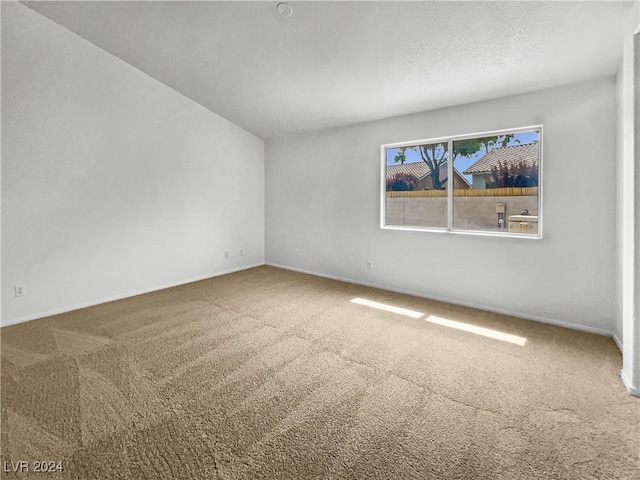 carpeted empty room with a textured ceiling