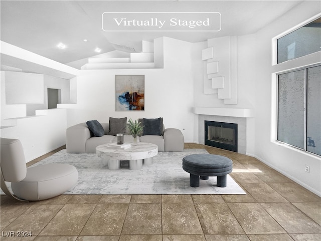 living room with a tiled fireplace and high vaulted ceiling