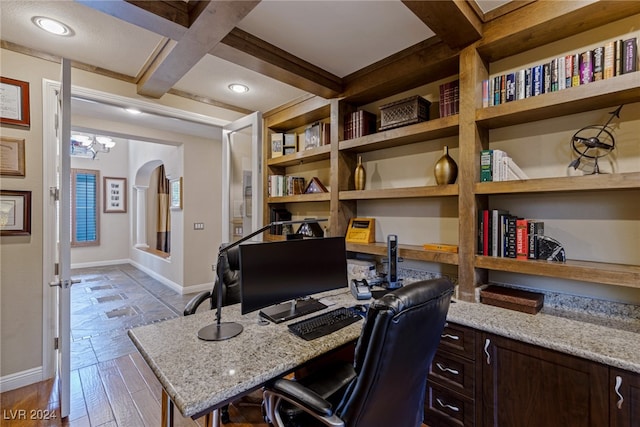 office space with light hardwood / wood-style floors, a notable chandelier, beam ceiling, and coffered ceiling