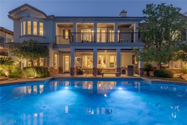 rear view of house with a patio area and a balcony