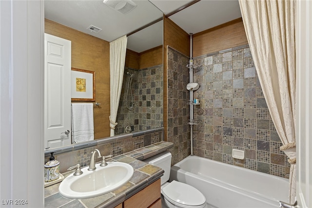 full bathroom with vanity, toilet, backsplash, and shower / tub combo