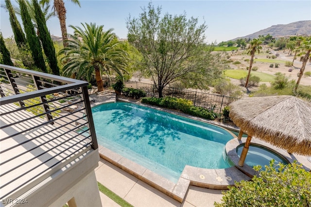 view of swimming pool with a mountain view and a gazebo