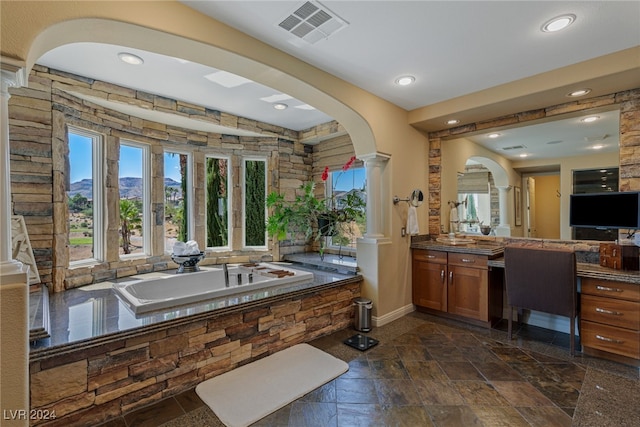 bathroom featuring a mountain view, vanity, a tub to relax in, and decorative columns