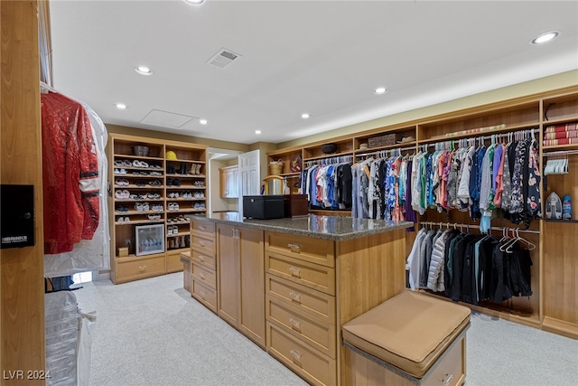 walk in closet with light carpet