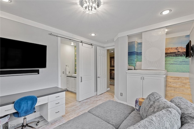 office featuring a barn door and light hardwood / wood-style flooring